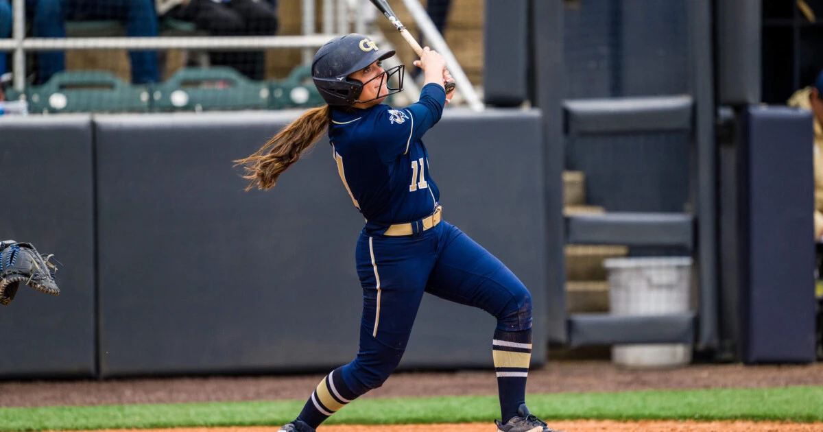 girl hitting the ball with bat during softball hitting practice