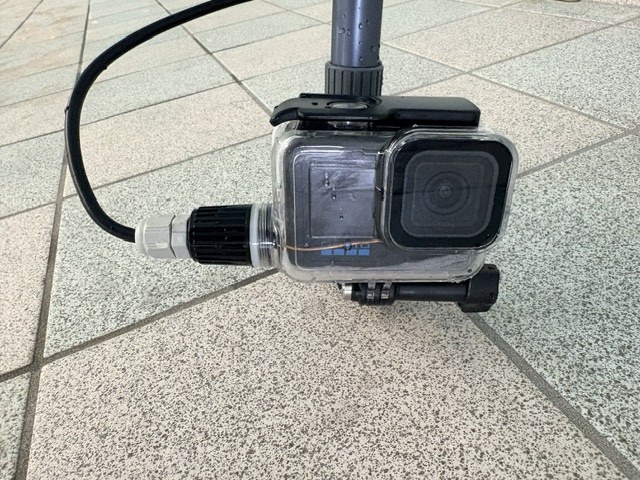 Modified GoPro underwater housing on a pole, with a coaxial cable leaving through a cable gland