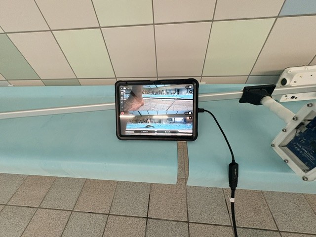 iPad mounted at the poolside showing the Video Delay Instant Replay split screen with live and delayed underwater footage